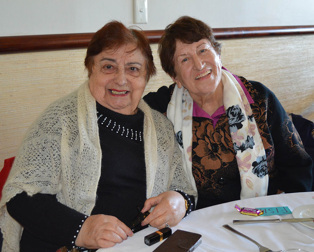 two women at table smiling