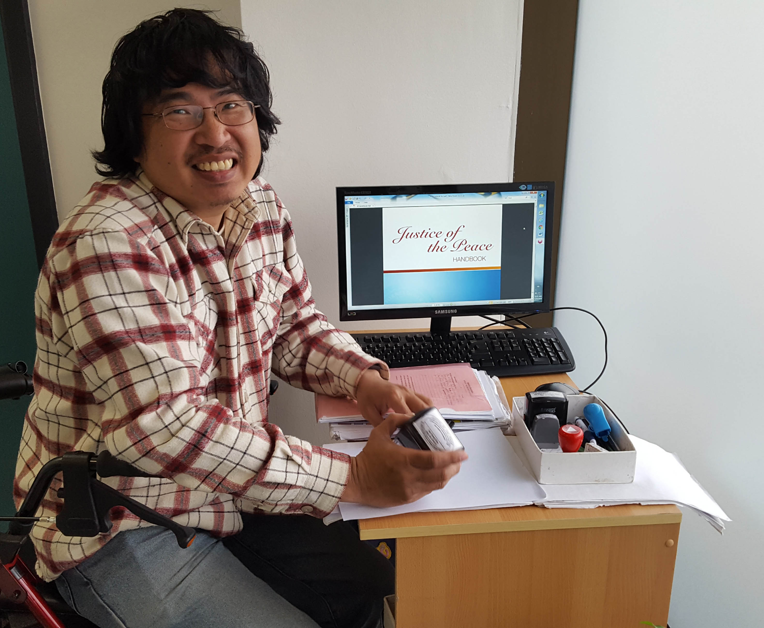 photo of happy volunteer Kevin, JNC Justice of the Peace, at his desk